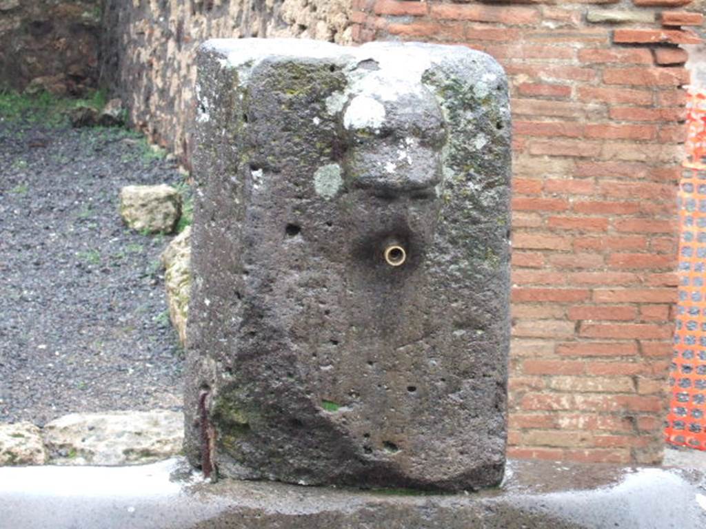 Fountain outside VII.14.13 and VII.14.14 on Via dellAbbondanza. December 2005. 
Head with helmet, possible relief of Minerva.
