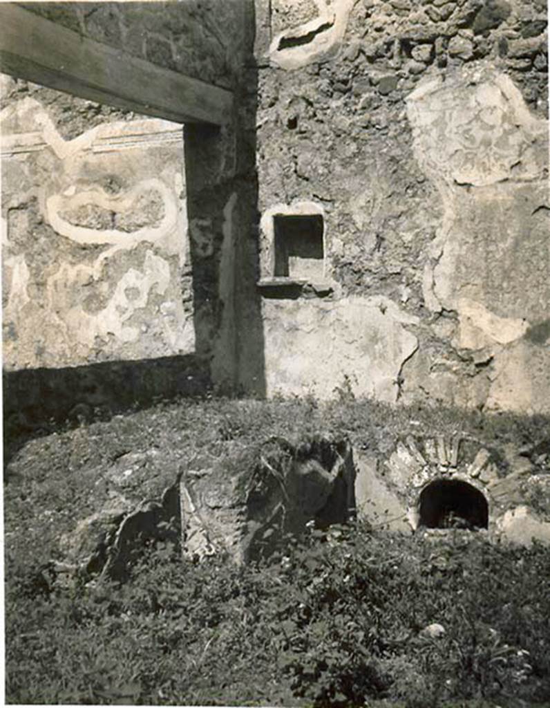 I.2.10 Pompeii. 1935 photo taken by Tatiana Warscher. Looking towards north wall of garden area with niche. On the left of the photo is the north wall of the triclinium, the wall with window overlooking garden area can also be seen on the left. On the right, the storage area under the north couch is visible.
See Warscher T., 1935. Codex Topographicus Pompeianus: Regio I.2. (no.22), Rome: DAIR, whose copyright it remains.
