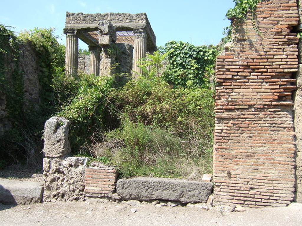 I.2.27 Pompeii. September 2005. Lava threshold or sill, leading to small room with steps to an upper floor. The room was linked at the rear, with the atrium of I.2.28.  Fiorelli thought the steps could have led to a separate dwelling for a lodger or perhaps a caretaker. See Pappalardo, U., 2001. La Descrizione di Pompei per Giuseppe Fiorelli (1875). Napoli: Massa Editore. (p.37).

