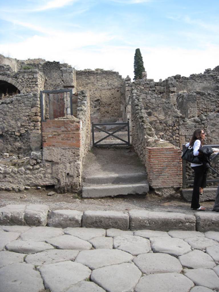 I.3.3 Pompeii. September 2010.  Looking east towards entrance doorway from across Via Stabiana.  Photo courtesy of Drew Baker.
According to Della Corte, this house was spacious and beautifully decorated, with temple-lararium in the atrium and peristyle on a higher level than the atrium.
Della Corte believed the house was owned by Epidius Fortunatus, because an amphora was found here, still containing honey in it, addressed to -
Mel P() P() CXXXIII
dat XXXXXIX s(emissem)
Epidio Fortunato
/
T() P() XXVIII
[]ens              CIL IV 5740
See Della Corte, M., 1965.  Case ed Abitanti di Pompei. Napoli: Fausto Fiorentino. (p.264)

