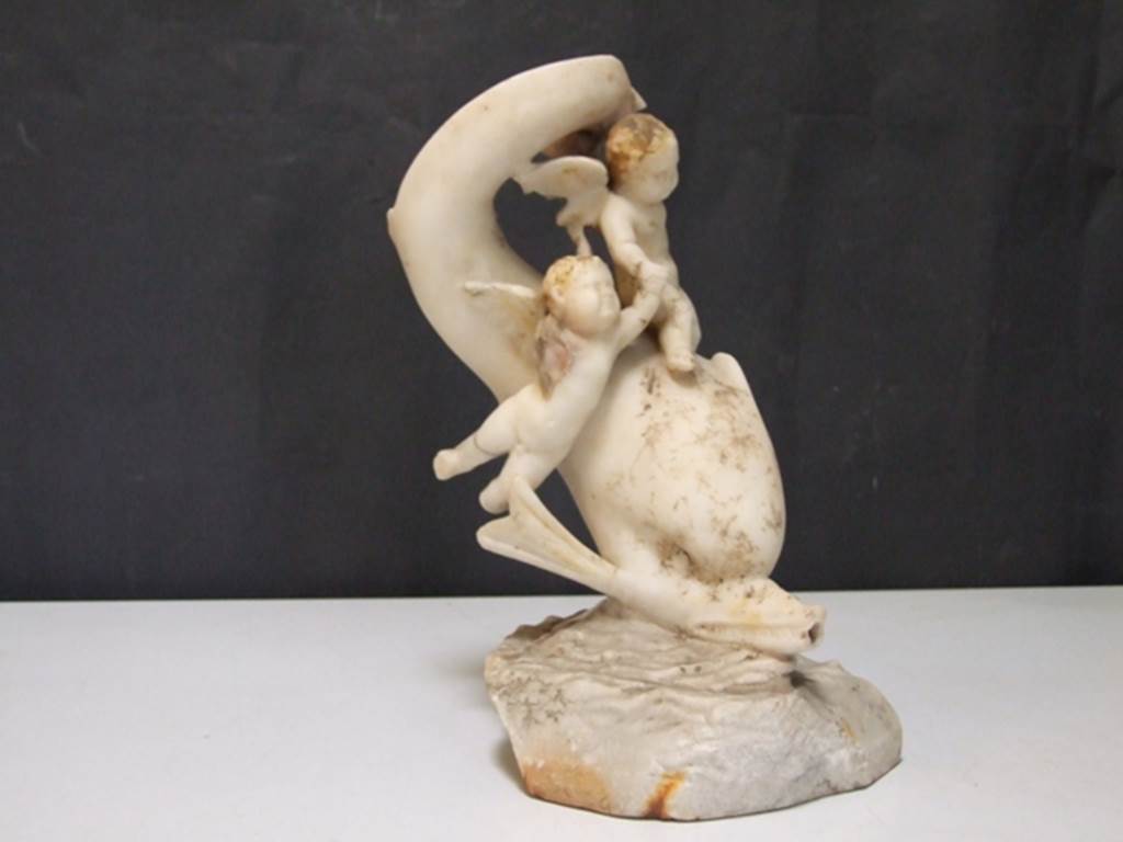 I.9.14 Pompeii.  Marble fountain statuette.  Two Amorini riding on dolphin.  SAP inventory number 8128.  Found in 1951.
