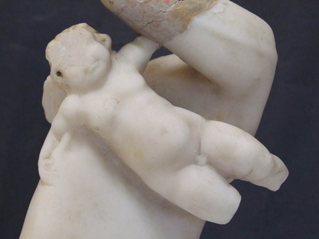 I.9.14 Pompeii.  Marble fountain statuette.  Amorino riding on dolphin.  Detail of amorino.  SAP inventory number 8129.  Found in 1951.