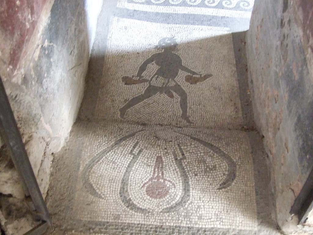 I.10.4 Pompeii. May 2006. Doorway to room 48, mosaic of figure carrying two askoi. 
An askos was an ancient Greek pottery vessel used to pour small quantities of liquids such as oil.
