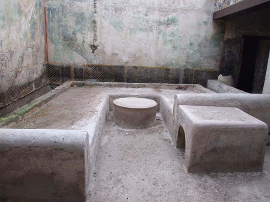 I.11.16 Pompeii. December 2007. Room 6, triclinium with round and square tables.
According to Jashemski, “The courtyard (a) at the rear of the hospitium (excavated in 1960) was separated from the roofed passageway on the south by a low wall 0.62m high. Most of the courtyard was occupied by a masonry triclinium (l. medius 3.80m, l. summus 2.73m, l. imus 4.15m, table 0.80m in diameter). There was a hearth at the end of the l. summus, which measured  0.77 x 0.90m.  A garden painting on the north and east walls of the courtyard gave the area the appearance of a garden.”
See Jashemski, W. F., 1993. The Gardens of Pompeii, Volume II: Appendices. New York: Caratzas. (p.53, and p.325, and figs 375-6)
