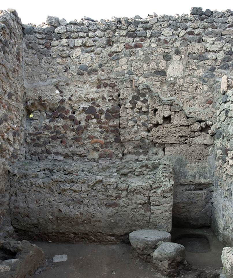V.1.13 Pompeii. Pre-2008. 
Hearth built against north wall of rear room “f”, with well in north-east corner. 
Photo by Hans Thorwid. 
“The rear room in the caupona, room f, has a large hearth built against the N wall, and two roughly built supports for a table along the E wall.”
Photo and words courtesy of the Swedish Pompeii Project.
