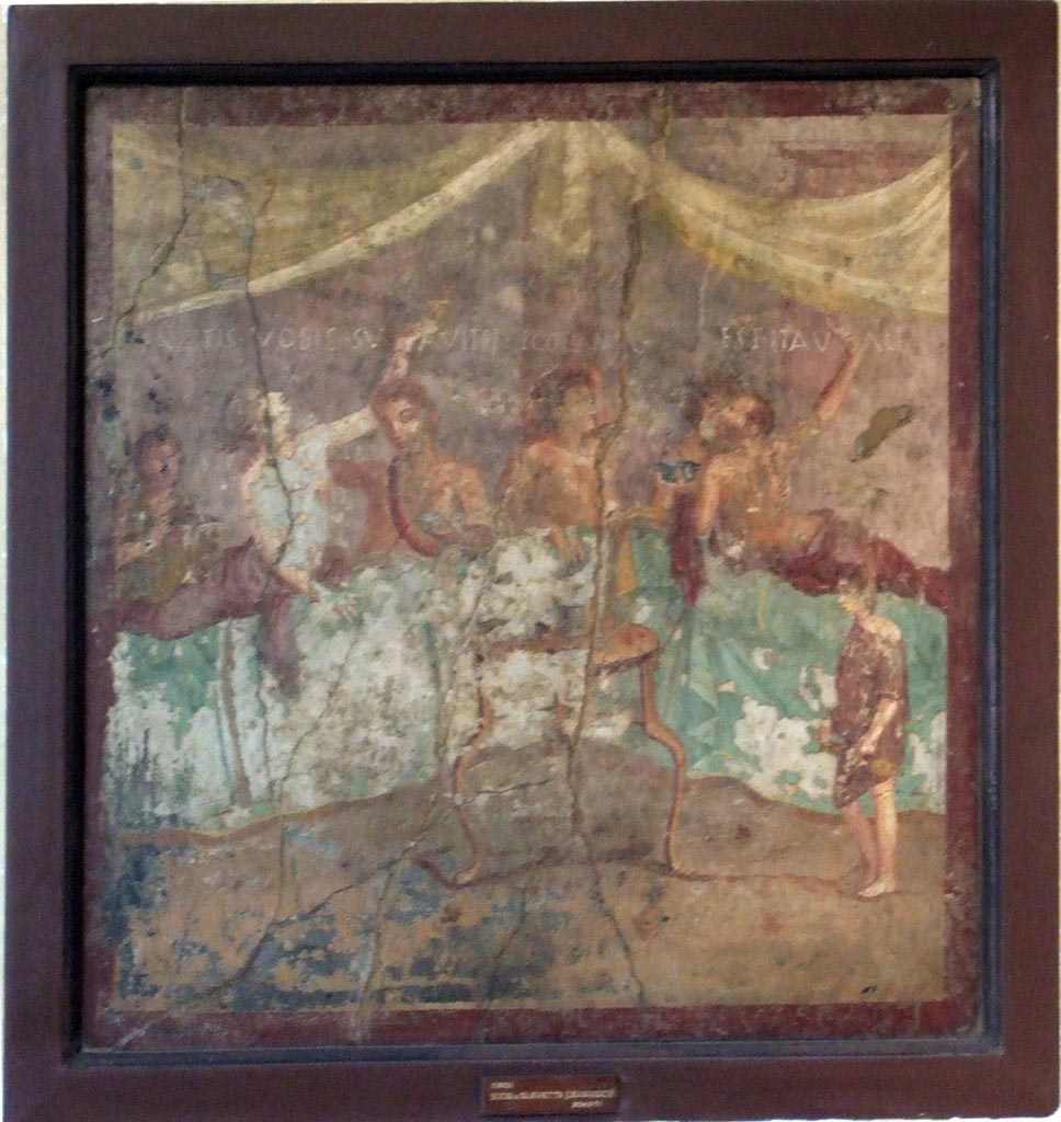V.2.4 Pompeii. Room 15, painting of banqueting scene from north wall of triclinium. 
The Commencement. The guests are reclining at table and a boy brings in dishes. 
Music and singing accompany the meal.
Now in Naples Archaeological Museum. Inventory number 120031.
See Ruesch A., Ed, 1909. Illustrated Guide to the National Museum in Naples. Naples: Richter. (p. 114-5).
There is an inscription in large letters above the guests.
Facite vobis svaviter ego canto  [CIL IV 3442a]
Est ita valeas    [CIL IV 3442b]
According to the Epigraphik-Datenbank Clauss/Slaby (See www.manfredclauss.de), [CIL 3442a] reads as:
Facitis vobis suaviter ego canto   [CIL IV 3442a]
See Richardson, L., 2000. A Catalog of Identifiable Figure Painters of Ancient Pompeii, Herculaneum. Baltimore: John Hopkins (p.176, 178) 
See Fröhlich, T., 1991. Lararien und Fassadenbilder in den Vesuvstädten. Mainz: von Zabern. Taf. 21,2.
See Gusman, P. (1900). Pompei, the city, its life and art, (p.313).
