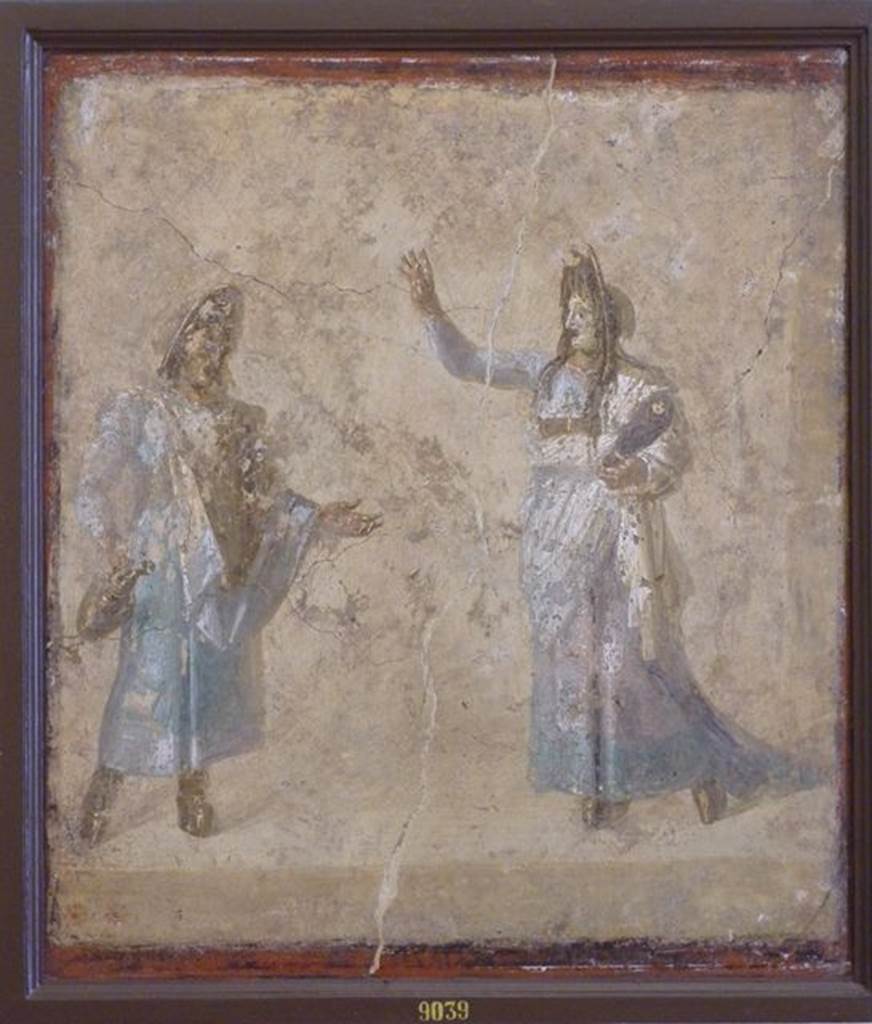 VI.9.6 Pompeii. Found on 1st July 1828 in room176, the west wall of the pseudo- peristyle.
Wall painting of masked actors possibly performing the myth of Auge because of the swaddled baby (Telephus?) in the arms of the woman.  Now in Naples Archaeological Museum. Inventory number 9039. See Helbig, W., 1868. Wandgemälde der vom Vesuv verschütteten Städte Campaniens. Leipzig: Breitkopf und Härtel. (1465).

