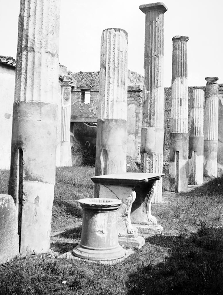 VI.9.6 Pompeii. W.875. Room 17, looking south along portico of pseudo-peristyle, with puteal and table.
Note the slots in columns for fixing the fence.
Photo by Tatiana Warscher. Photo © Deutsches Archäologisches Institut, Abteilung Rom, Arkiv. 


