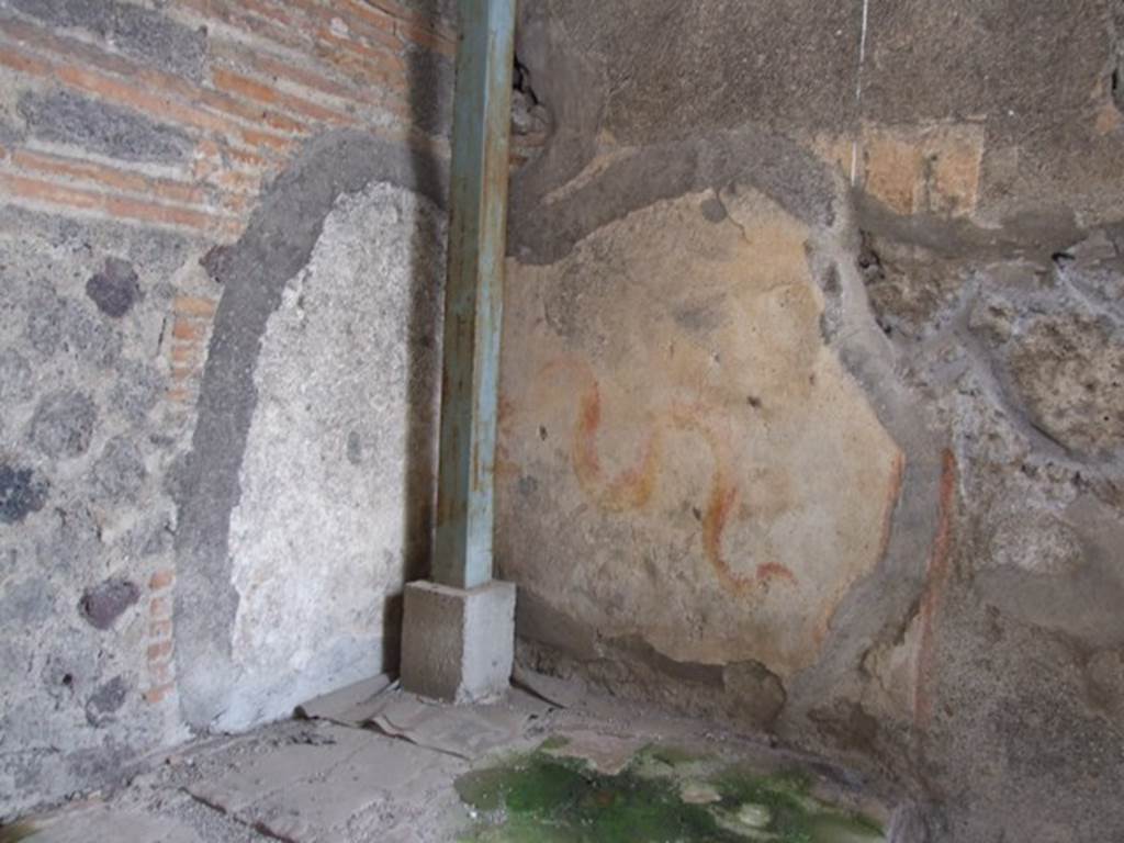 VI.9.7 Pompeii. March 2009. Room 4, painted lararium in north-west corner of kitchen.  
According to Boyce, in the north-west corner above the hearth is a painting of two red and yellow serpents. The one on the right has red crest and beard; the head of the other is destroyed. They approach an altar. There are garlands above.
See Boyce G. K., 1937. Corpus of the Lararia of Pompeii. Rome: MAAR 14.  (p.50, 178)
