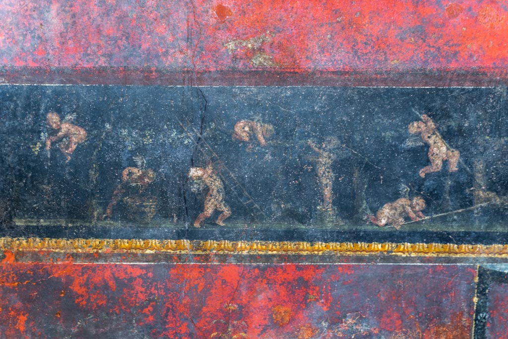 VI.15.1 Pompeii. March 2023. 
Predella in centre of north wall painted panel of cupids gathering and pressing grapes. Photo courtesy of Johannes Eber.

