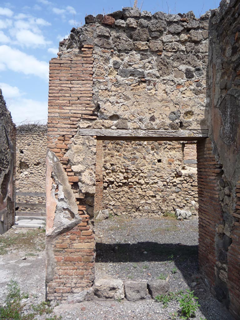 VII.1.36 Pompeii. October 2009. Looking north to doorway to room, on east side of entrance corridor (on left of photo), in north-east corner of atrium.
Photo courtesy of Jared Benton.
According to Breton, on the left side of the entrance corridor was the doorway to a very large room, which may have been the flour store, although it may have been used for the animals that turned the mills.
See Breton, Ernest. 1870. Pompeia, Guide de visite a Pompei, 3rd ed. Paris, Guerin. 
