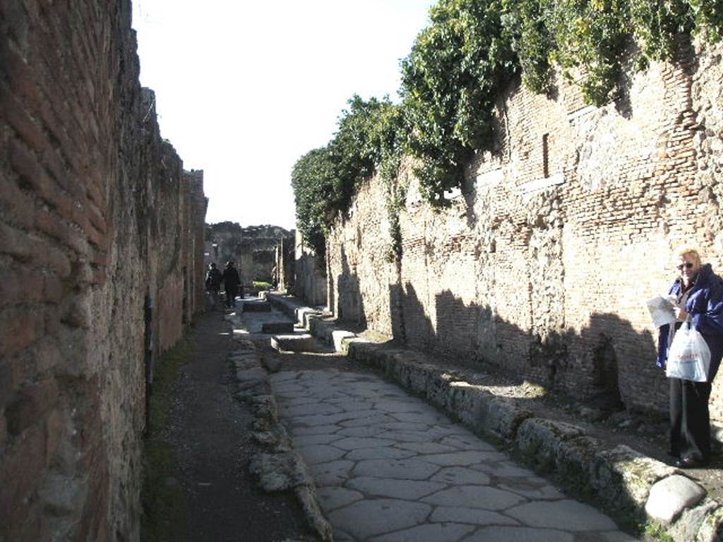 Pompeii. December 2004. Via degli Augustali looking west at side wall of VII.2.1 