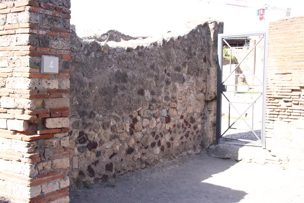 VII.7.4 Pompeii. October 2023. 
West wall of shop-room, with doorway into atrium of VII.7.5 in north-west corner. Photo courtesy of Klaus Heese.
