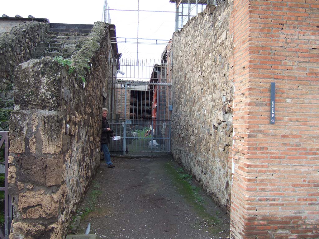 VII.7.30 Pompeii. December 2005. Entrance corridor leading west.
According to Garcia y Garcia, in this area reconstructed by Maiuri, were kept all the antiquities from pre-Samnite Pompeii.
This area was completely destroyed by bombing in 1943 together with the rooms on the south side, part of the Temple of Apollo, known as la sagrestia.
However, the major loss was the destruction of the collection from the archaic period.
The area has now been restored and altered with modern modifications, and once again used as a store for archaeological materials.
See Garcia y Garcia, L., 2006. Danni di guerra a Pompei. Rome: LErma di Bretschneider. (p.117)
