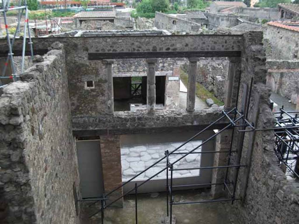 IX.12.2 Pompeii. May 2010. Doorway to stairs to upper floor, on left, and IX.12.1, lower rooms. 
Looking south towards and across Via dellAbbondanza.  The upper wall, on the left, would be the east wall of the large front room on the upper floor. The north wall would have been approximately along the line of the lower photo. Found on this north wall, and left in situ, opposite the three windows, were the remains of the painting of Bellerophon and flying Pegasus receiving the letter of Proetus, here called Chryses.  On the west wall, only a few fragments of another painting of the liberation of Andromeda were also found in this room, showing the names of Andromeda and Perseus, painted near the remaining fragments of the figures.
See Della Corte, M., 1965.  Case ed Abitanti di Pompei. Napoli: Fausto Fiorentino. (p.321).
Spinazzola, V. Pompei, alla luce degli Scavi Nuovi di Via dellAbbondanza (Anni 1910-1923), Vol.2, p.720, fig.693-7.
(Note: Della Corte wrote that the painting was left in situ, we do not know where it is now, perhaps in the deposits! When did the north wall disappear, perhaps just wear and tear perhaps the 1980 earthquake  another mystery to solve).
