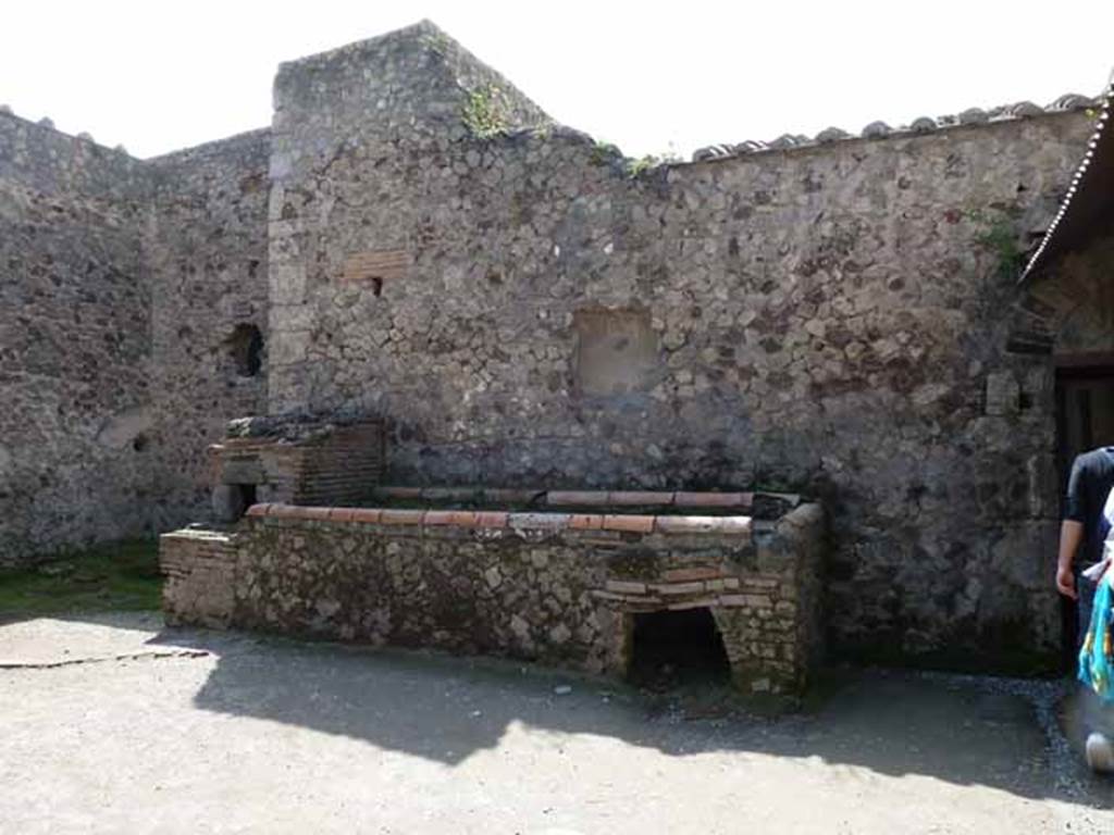 Villa of Mysteries, Pompeii. May 2010. Room 61, west wall with hearth and oven, and remains of niche. According to NdS, another niche lararium was above the podium of the hearth and oven. The stucco had fallen and brought to light a part of an ancient painted lararium, for all its simplicity, not without interest. At the side were the remains of a painted helmeted Minerva, and of another divinity, perhaps Vulcan. See Notizie di Scavi, 1910, p.141-2.
