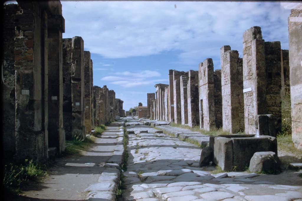 Via della Fortuna, Pompeii. November 1958. 
Looking west between VII.4 and VI.13 towards junction with Via dell Foro, and Arch on Via Di Mercurio, with VI.13, on right. 
Photo courtesy of Rick Bauer.
