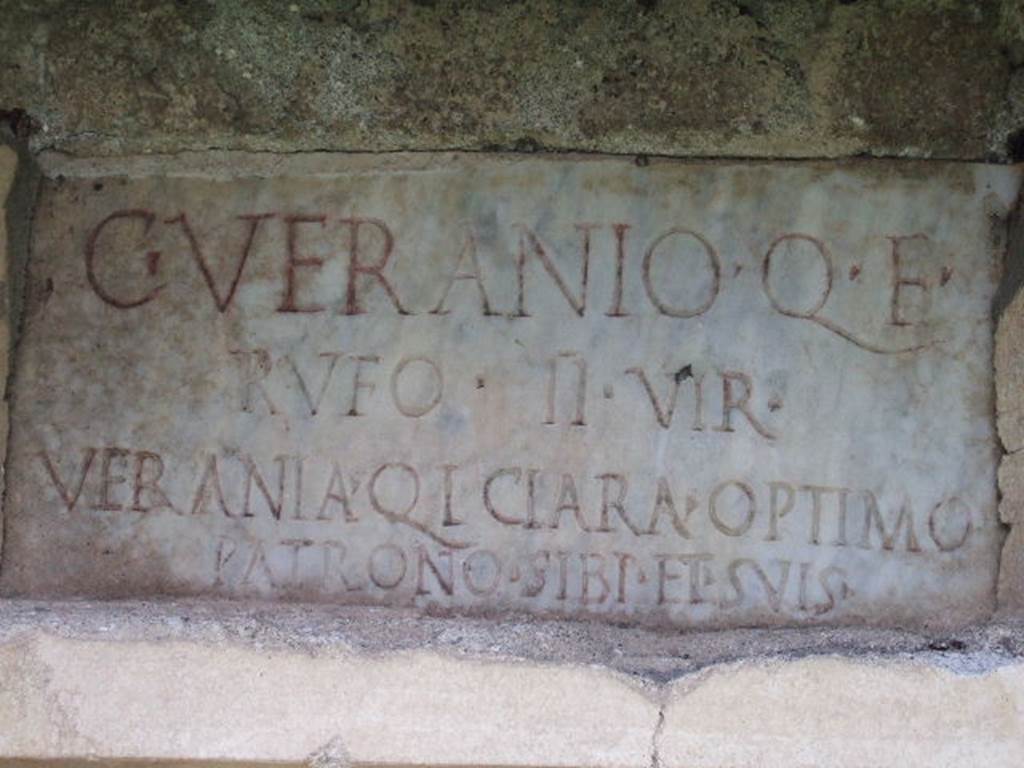 FPNF Pompeii. December 2005. Marble plaque on south side, it reads –

C . VERANIO Q. F.
RVFO  II VIR
VERANIA Q. L. CLARA OPTIMO
PATRONO SIBI ET SVIS

According to D’Ambrosio and De Caro, this expands to

C(aio) Veranio, Q(uinti) f(ilio),
Rufo II vir(o)
Verania Q(uinti) l(iberta), Clara optimo
patrono, sibi et suis

See D’Ambrosio A. and De Caro S., 1988. Römische Gräberstraßen. München: C.H.Beck. p. 209.