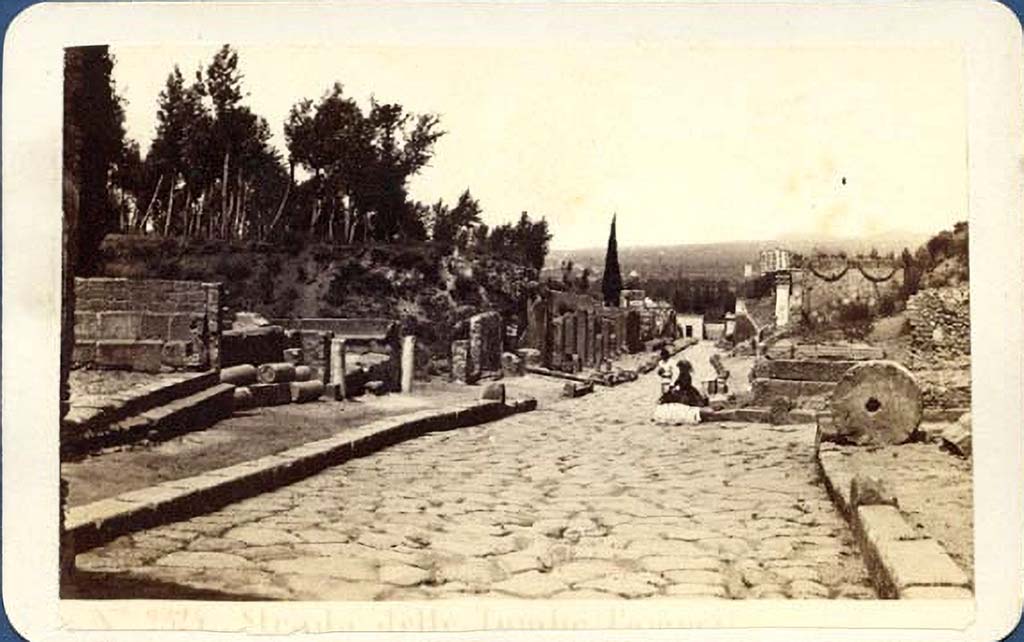 Via dei Sepolcri. Old photo c.1869 by G. Sommer, no. 2325. 
Looking west along the Via dei Sepolcri past the offset crossroads with Via Pomeriale.
The lady is sitting at the front of HGE03, on the corner of the Via Pomeriale.
Photo courtesy of Giovanni Dall'Orto, Wikimedia Commons. See on Wikimedia Commons.
