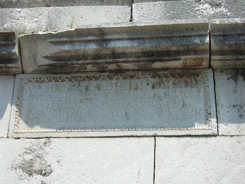 HGE37 Pompeii. May 2006. Marble plaque on south side. 
On the plaque is the inscription: 
M. ALLEIO LVCCIO LIBELLAE PATRI AEDILI
II VIR PRAEFECTO QVINQ(uennali) ET M. ALLEIO LIBELLAE F
DECVRIONI VIXIT ANNIS XVII LOCVS MONVMENTI
PVBLICE DATVS EST ALLEIA M F DECIMILLA SACERDOS
PVBLICA CERERIS FACIVNDVM CVRAVIT VIRO ET FILIO

This differs from the east side plaque where the last word is FILO rather than FILIO. 
The plaque is also wider and the inscription is on fewer (five) lines.
According to Epigraphik-Datenbank Clauss/Slaby (See www.manfredclauss.de) this reads

M(arco) Alleio Luccio Libellae patri aedile
IIvir(o) praefecto quinq(uennali) et M(arco) Alleio Libellae f(ilio)
decurioni vixit annis XVII locus monumenti
publice datus est Alleia M(arci) f(ilia) Decimilla Sacerdos
publica Cereris faciundum curavit viro et filio      [CIL X 1036  first part]
