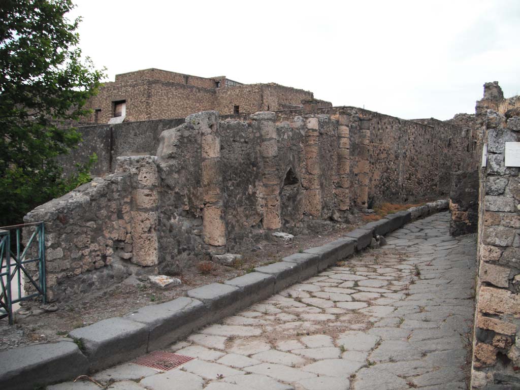 Vicolo dei Soprastanti, Pompeii. June 2012. Looking east. Photo courtesy of Ivo van der Graaff.
According to Van der Graaf –
“Given the strategic importance of the battlements, perhaps it is not without coincidence that the only truly intact part of the wall top that survives is primarily ornamental. It stretches along the edge of a cliff bordering the street known as the vicolo dei Soprastanti, where it functioned to emphasize the city’s edge. The section is composed of six travertine Doric columns engaged in an opus incertum curtain…………..
With the exception of a small triangular window designed as a viewing port or firing slit, the wall has no real military purpose (see Fig. 3.12).
See Van der Graaf, I. (2018). The Fortifications of Pompeii and Ancient Italy. Routledge, (p.69-70).
