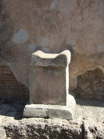 Pompeii, street altar on west side wall of I.11.1, September 2005.
According to Della Corte, found written in charcoal probably by a passer-by was CIL IV 8426:
[Per] Lares sanctos 
rogo tu et…… [CIL IV 8426]
This was written, approximately in the left top corner of the photo, although none of the wording has been conserved.
According to Cooley, CIL IV 8426, appeared to the left of a street corner shrine, where a painting of a Lar and a serpent can still be faintly seen. On top of the altar were found the carbonised remains of a sacrifice of a chicken. She translated the wording as  –
“By the sacred Lares, I ask you …..”  [CIL IV 8426]
See Cooley, A. and M.G.L., 2004. Pompeii : A Sourcebook. London : Routledge. (p.109)

