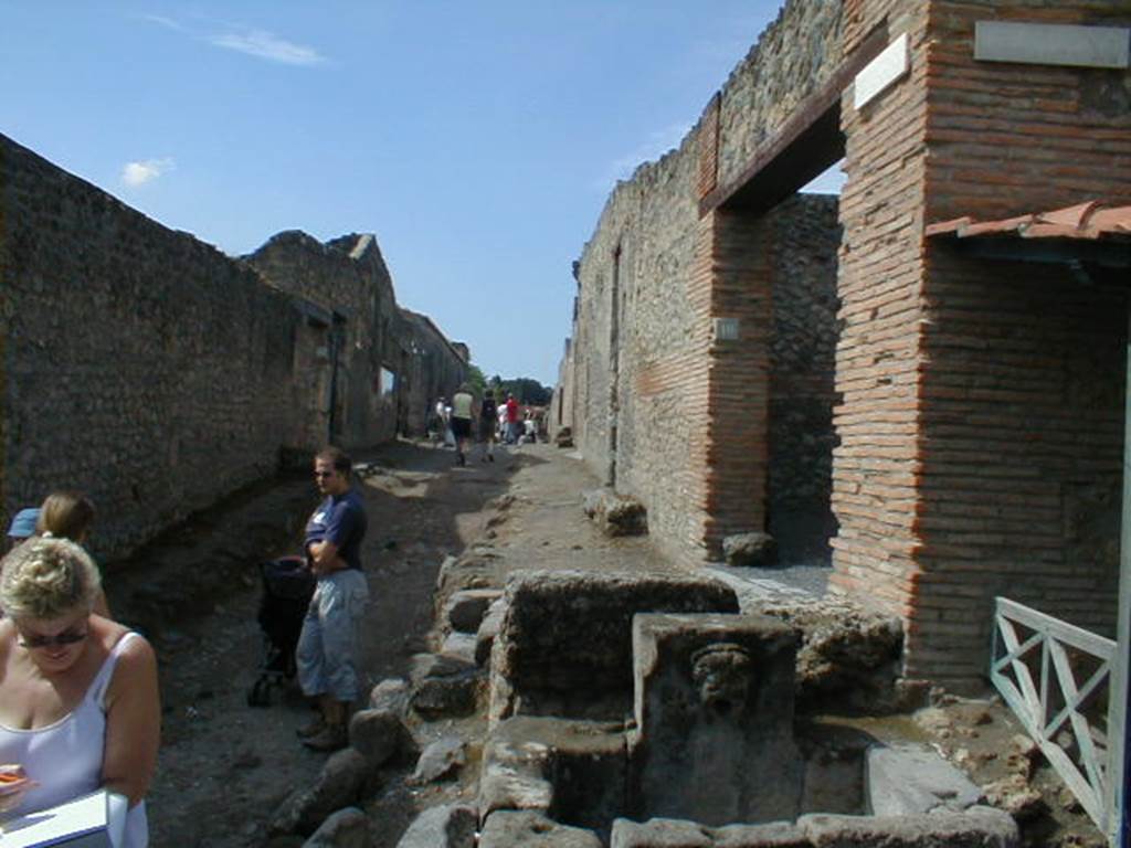 I.14 Pompeii. Fountain on Via di Castricio looking west, May 2006. with street shrine by I.13.10, on right.