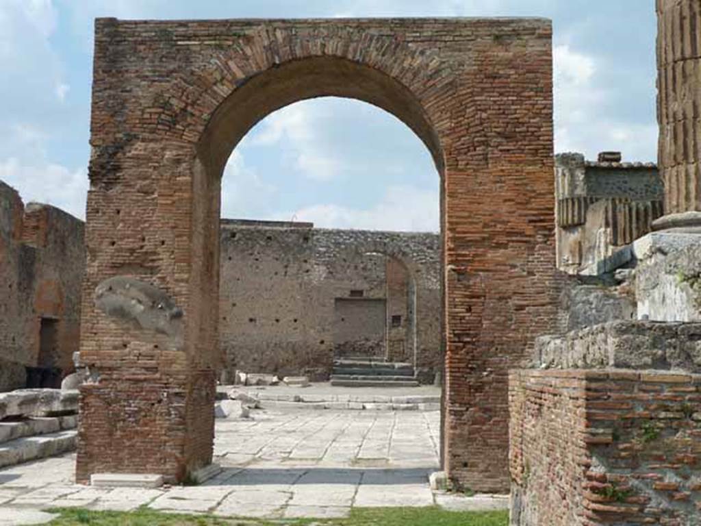 Arch of Augustus. May 2010. Looking north to the arched entrance in the north-west corner of the Forum.