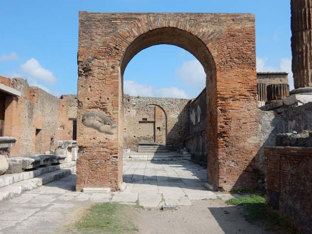 Arched entrance in north-west corner of Forum. May 2010. Looking north through arch in the north wall of the Forum.
On the right is the west side of the Temple of Jupiter.

