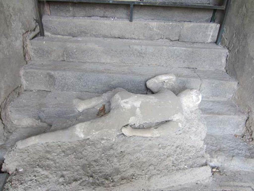 VII.16.17-22 Pompeii. May 2012. Plaster cast of lowest victim at foot of staircase. Photo courtesy of Marina Fuxa.
