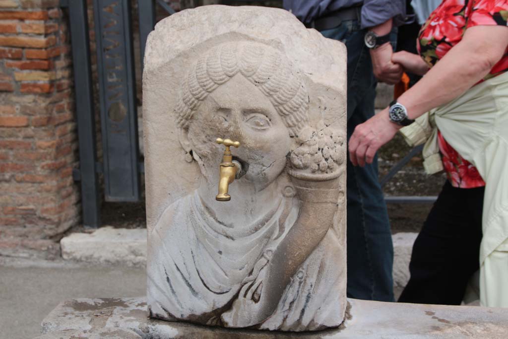 Fountain outside VII.9.67 and VII.9.68. April 2014. Relief of head of Fortuna (Abbondanza) with cornucopia.
Photo courtesy of Klaus Heese.
