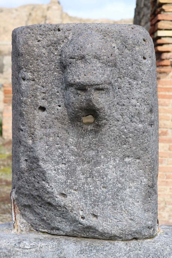 Fountain outside VII.14.13 and VII.14.14 on north side of Via dell’Abbondanza. December 2018.  
Head with helmet, possibly a relief of Minerva. Photo courtesy of Aude Durand.
