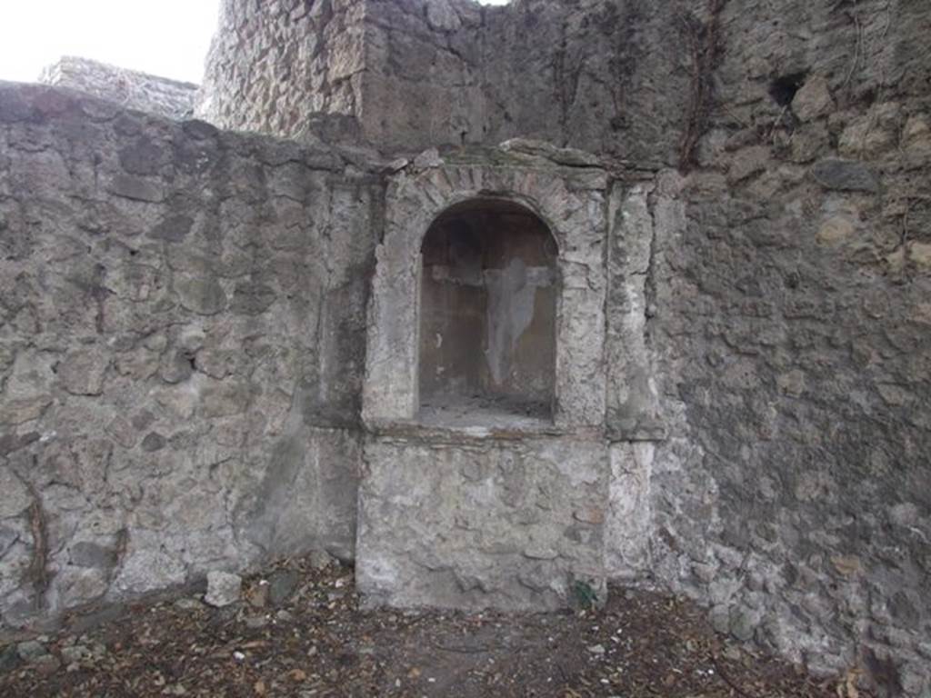 VIII.6.6 Pompeii. December 2007. Aedicula in south-west corner.
According to Boyce –
this simple aedicula (h.2.45 by w.1.13) consisted of a simple podium (h.0.90) and a niche with an arched opening (h.10.5,w.0.65) built above it.
The interior of the niche is an unusual pentagonal shape, the floor is paved with red stucco ornamented with little white stones.
The rest of the structure was uniform white, except for the tympanum, which was yellow with a star in white relief in the middle.
Before the shrine and close to the south wall, stood a small masonry altar, originally coated with white stucco.
See Boyce G. K., 1937. Corpus of the Lararia of Pompeii. Rome: MAAR 14. (p.78, No.374, Pl.33,1)
See Giacobello, F., 2008. Larari Pompeiani: Iconografia e culto dei Lari in ambito domestico. Milano: LED Edizioni, (p.283 no.V74)

