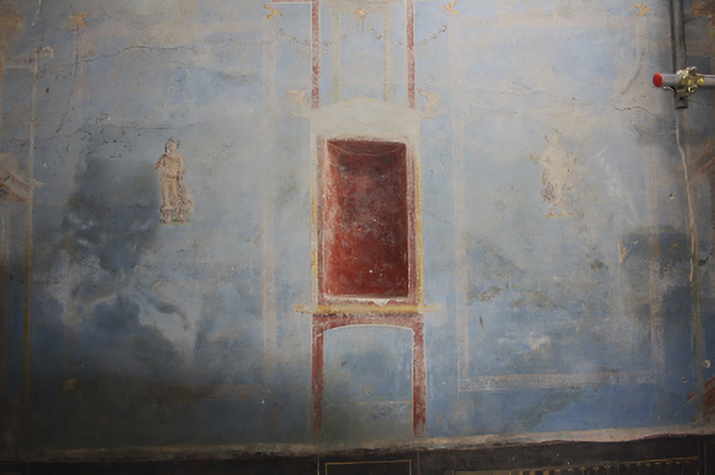 IX.10 Pompeii. House on west side of insula, south of IX.10.1. June 2024. Sacrarium room 32 west wall with blue decoration, showing niche in red with figures either side.
On the left is the divinity of Summer. On the right is the divinity of Winter.
A similar pattern exists on the east wall with representations of the divinities of Autumn and Spring.
See PAP 15-E-Journal-Sacrario-Regio-IX.pdf, fig. 12. p. 12,
See also photos in the E-Journal (pages 12 and 13) of: Summer – fig. 20, Winter – fig. 21, Autumn - fig. 22 and Spring - fig. 23.
Photograph © Parco Archeologico di Pompei.
