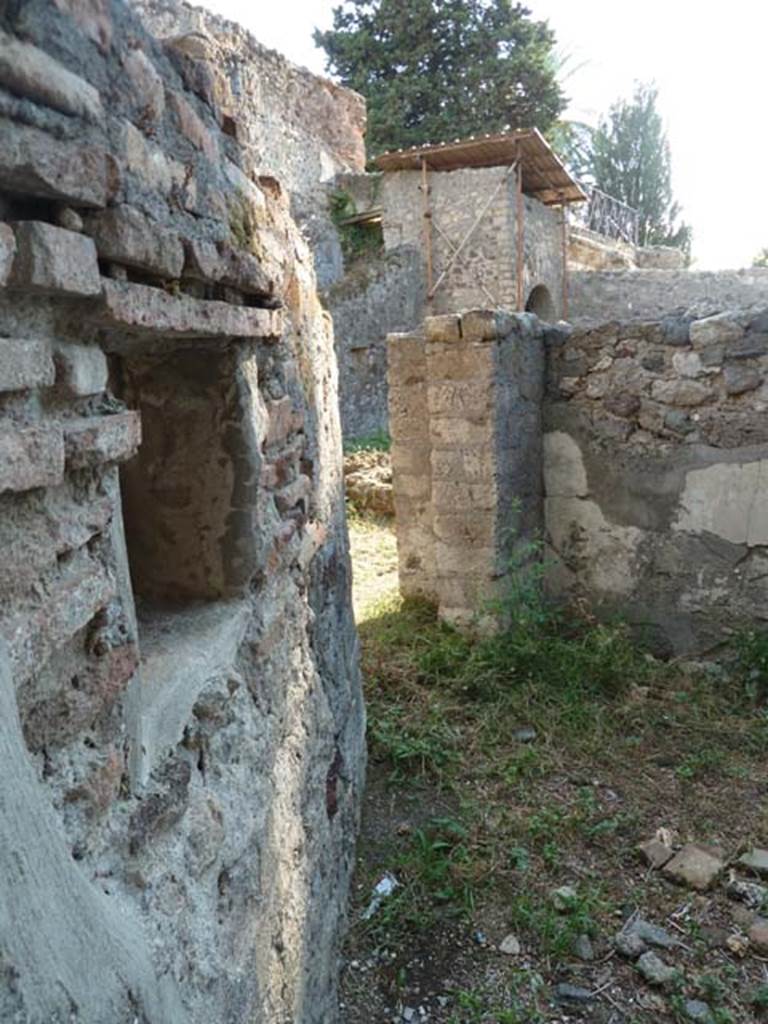 HGW25 Pompeii. September 2015. Looking west across room towards doorway to servants area. In the background is the supporting arch of the east end of the upper terrace. 
