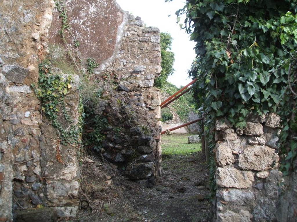 VI.16.31 Pompeii. December 2004. Looking east from entrance doorway. The doorway led immediately into a short and wide fauces A, with earth floor and rustic walls. In the centre left of this photo can be seen the remains of the ramps of masonry stairs that led above. On the left of this photo was a doorway into a large room B, which was as rustic as the corridor.
In the top of the west wall was a window, and there was a niche in the south wall. In the south-west corner was a low masonry structure. According to Eschebach room B was the kitchen.
See Eschebach, L., 1993. Gebäudeverzeichnis und Stadtplan der antiken Stadt Pompeji. Köln: Böhlau. (p.231)
According to Boyce, in the kitchen (?) on the left side of the fauces, in the south wall above the hearth (?) was a rectangular niche (h.0.30, w.0.22, d.0.22, height above the floor 1.50). See Boyce G. K., 1937. Corpus of the Lararia of Pompeii. Rome: MAAR 14. (p.59, no.228)
According to Giacobello, in the kitchen (room E) was a niche on the south wall, near the hearth. Today there is no trace. See Giacobello, F., 2008. Larari Pompeiani: Iconografia e culto dei Lari in ambito domestico.  Milano: LED Edizioni. (p.186)
