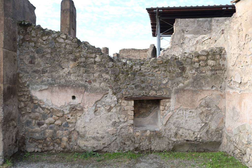 VII.1.7 Pompeii. December 2018. West wall with niche/recess. Photo courtesy of Aude Durand.
Boyce said –
In the west wall is a rectangular niche (h.0.60, w.0.54, d.0.28, h. above the floor 0.65) which does not look like a shrine, but it was described as an aedicula in the excavation report.
Bull. Arch. Nap., N.S., iv, 1856, 164.
See Boyce G. K., 1937. Corpus of the Lararia of Pompeii. Rome: MAAR 14. (p.60, no. 232).
