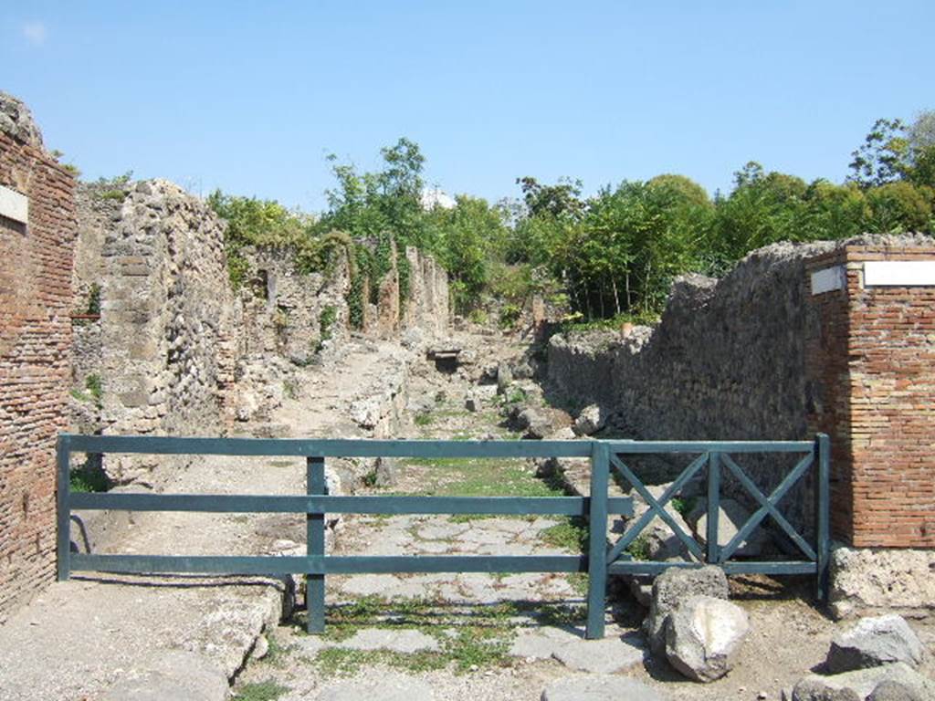 I.2, on left, Pompeii. September 2005.  Vicolo del Conciapelle looking east.   North side of I.1.9,on right.