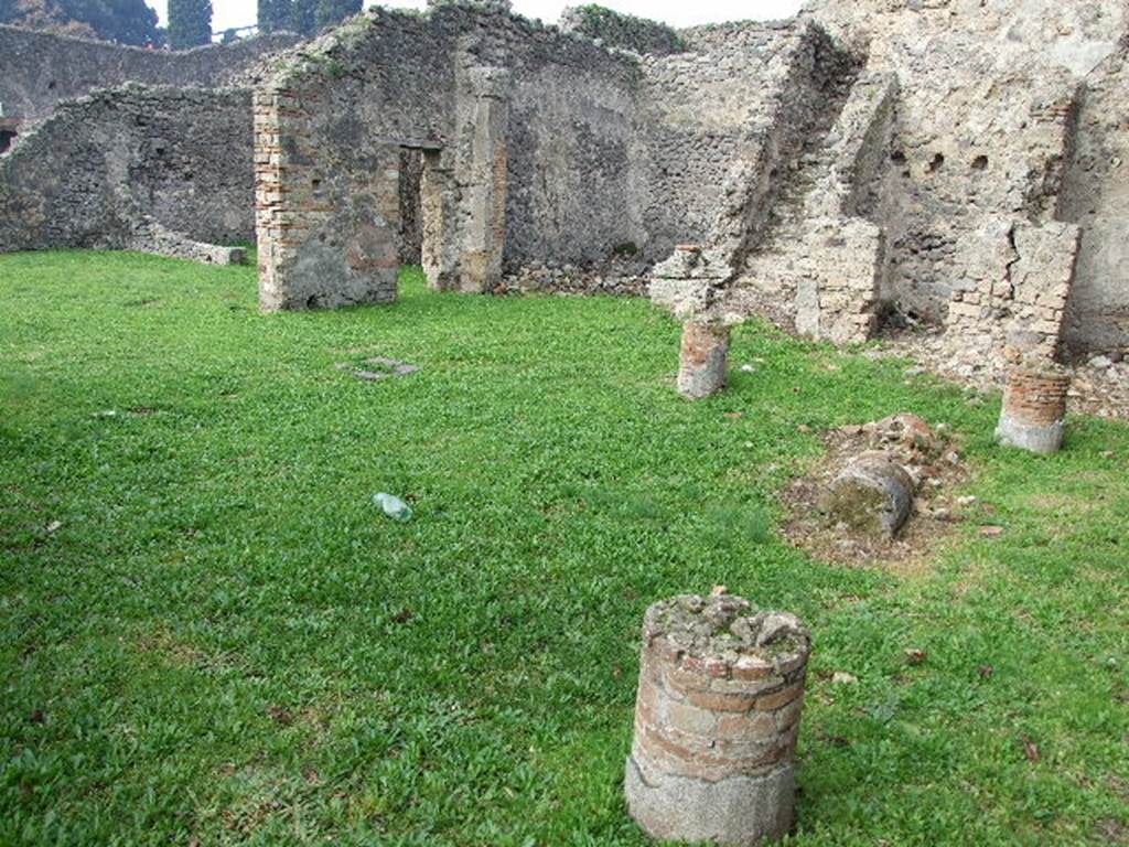 I.2.6 Pompeii. December 2006. Looking north west across peristyle to north side of house, and the atrium.  According to Jashemski, the west portico was entered directly from the atrium through the two doors. The garden had a portico on four sides and was supported by eight stuccoed brick columns.  See above, now only stumps survive.
See Jashemski, W. F., 1993. The Gardens of Pompeii, Volume II: Appendices. New York: Caratzas. (p.22)
