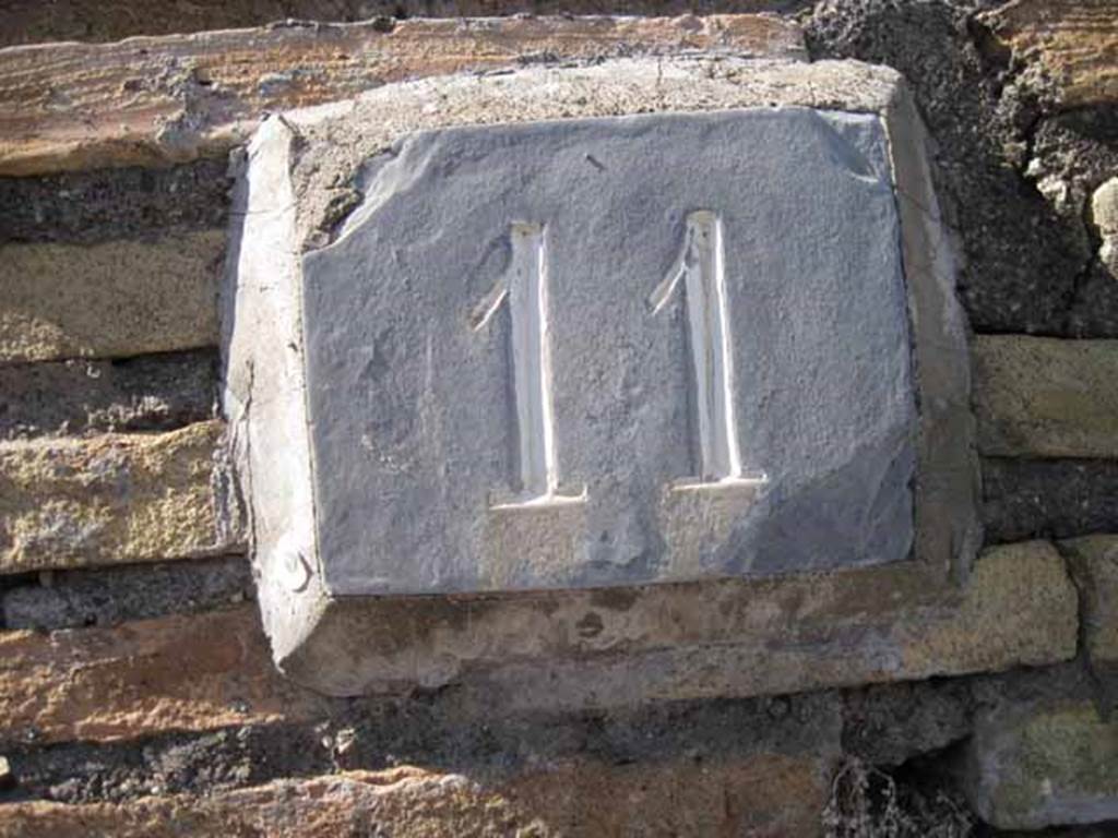 I.2.11 Pompeii. September 2010. ID number plate on north wall of bar.
Photo courtesy of Drew Baker.
