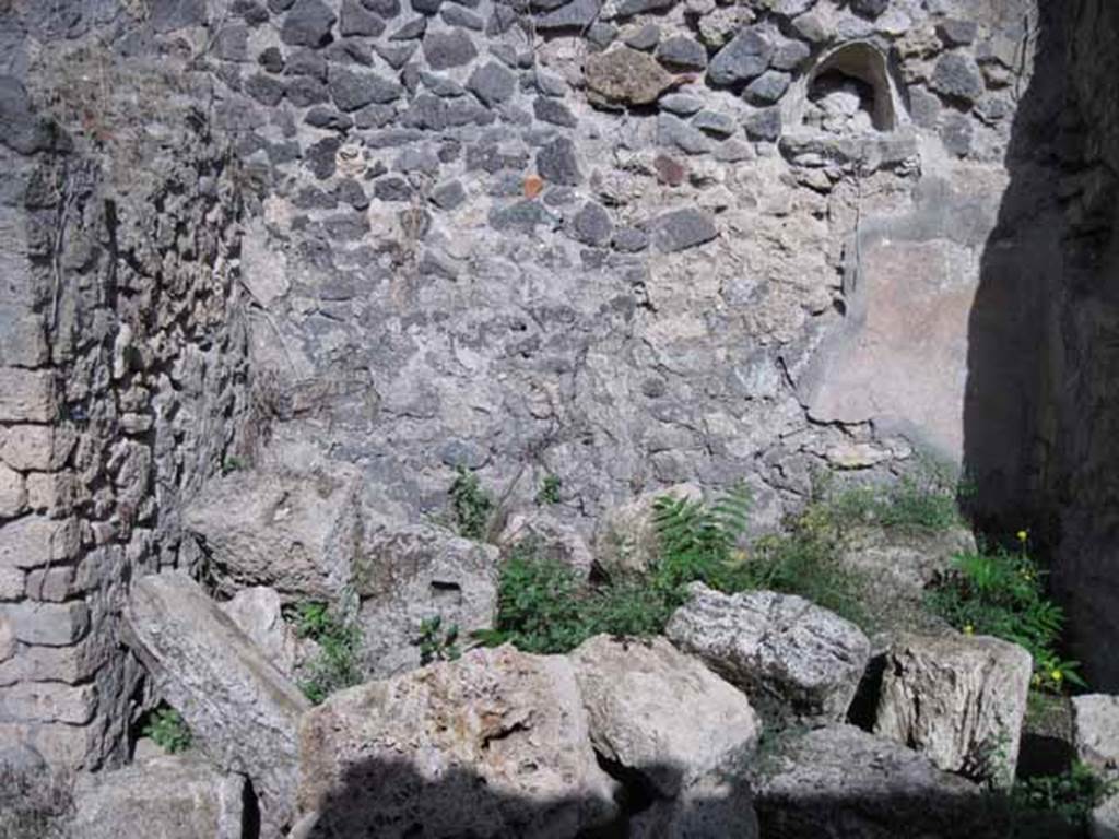 I.2.23 Pompeii. September 2010. East wall of entrance area, with niche.  Photo courtesy of Drew Baker. According to Garcia y Garcia, the dividing wall of a rustic room in this area was destroyed due to the 1943 bombing.
See Garcia y Garcia, L., 2006. Danni di guerra a Pompei. Rome: LErma di Bretschneider. (p.37)
