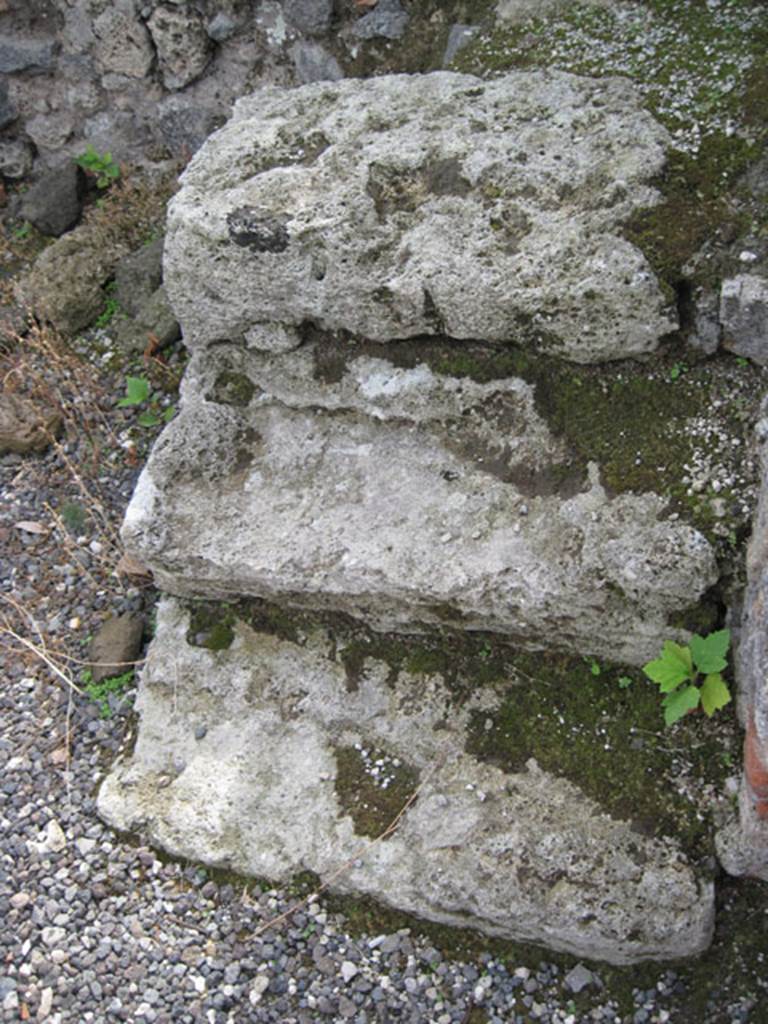 I.3.2 Pompeii. September 2010.  Detail of stone steps against the south wall in south-west corner. Photo courtesy of Drew Baker.
According to Fiorelli, on the right of the entrance doorway was a staircase similar to the one in the preceding shop. He described that one as a wooden stepladder, reached by similar three stone steps. See Pappalardo, U., 2001. La Descrizione di Pompei per Giuseppe Fiorelli (1875). Napoli: Massa Editore. (p.38)
