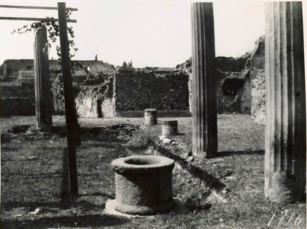 I.3.3 Pompeii. 1935 photograph taken by Tatiana Warscher from the north-east corner of the peristyle. To the right, the north portico with a pipe from the acqueduct. The pipe was also found along the west portico. The remains of the pipe of the acqueduct could be seen in both the north and west portico.  In the north-west corner, on the right, the recess for the triclinium couch can be seen. The house can be found opposite the theatres.
See Warscher, T, 1935: Codex Topographicus Pompejanus, Regio I, 3: (no.10a), Rome, DAIR, whose copyright it remains.  
According to Jashemski, quoting Mau, there were two cistern openings, one in the north-east corner of the garden, with a tufa puteal, the other opening in the corresponding corner of the portico. Water emptied at the north-east corner from the gutter into the cistern and into the street at the south-east and south-west corners. Between the gutter and the portico there was an aqueduct pipe which came out of the first column, counting from the south, on the west portico.  Supporting itself on the second column on the west side, the pipe rose to give a jet of water in the gutter. Flanking the west portico and the one to the north, it disappeared towards the north-east. Twice, on the west side, by a widening of the pipe, it was possible to let water flow into the gutter. 
The gutter at precisely these two points had openings towards the garden which the apparatus served to water. Before and after the widening of the pipe, it could be closed by a key.  Two branches of this pipe entered the room in the Subterannean Level in which there was a tank, off the north-west corner of the peristyle.
See Mau, BdI, 1874, pp.181-182.
See Jashemski, W. F., 1993. The Gardens of Pompeii, Volume II: Appendices. New York: Caratzas, (p.26).
