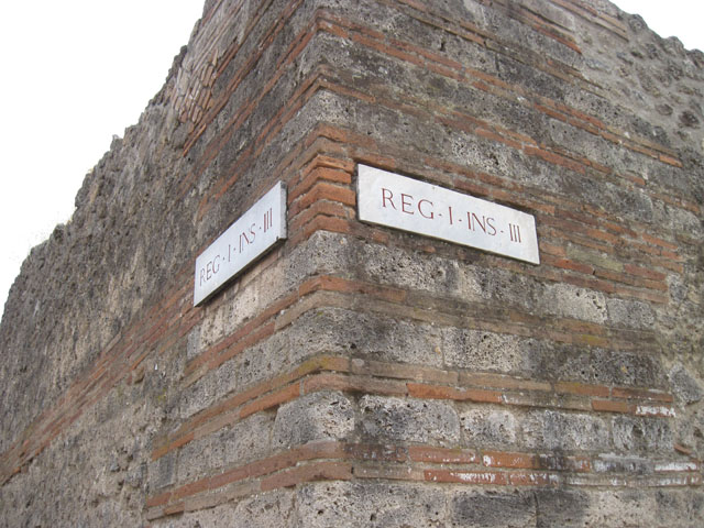 I.3.24 Pompeii. September 2010. Exterior wall on corner of Vicolo del Menandro (image right) and vicolo del Citarista (image left).  Photo courtesy of Drew Baker.
