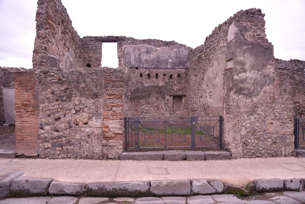 I.4.18 Pompeii. September 2018. Looking south on Via dell’Abbondanza towards entrance. Photo courtesy of Aude Durand.
Della Corte thought this would be the shop and dwelling of the Sabinus that had acclaimed his neighbour M. Epidio Sabino, on the right pilaster of I.4.17:
Sabinus dissignator cum plausu facit (part of CIL IV 768, see I.4.17).
See Della Corte, M., 1965.  Case ed Abitanti di Pompei. Napoli: Fausto Fiorentino, p. 255.
