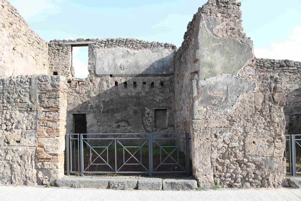 I.4.18 Pompeii. September 2018. Looking south on Via dellAbbondanza towards entrance. Photo courtesy of Aude Durand.
Della Corte thought this would be the shop and dwelling of the Sabinus that had acclaimed his neighbour M. Epidio Sabino, on the right pilaster of I.4.17:
Sabinus dissignator cum plausu facit (part of CIL IV 768, see I.4.17).
See Della Corte, M., 1965.  Case ed Abitanti di Pompei. Napoli: Fausto Fiorentino, p. 255.
