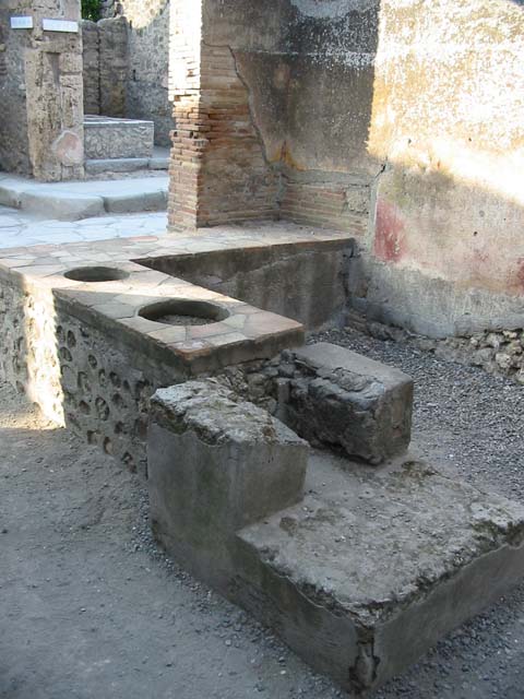 I.4.27 Pompeii. May 2010. West wall of front sales-room, with latrine in the south-west corner.