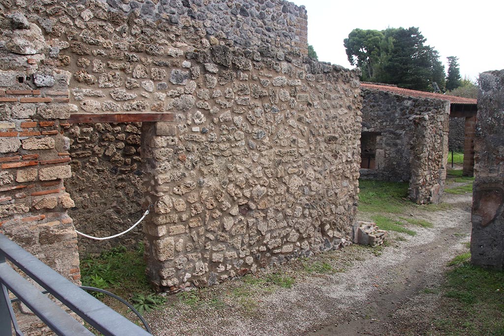 I.5.2 Pompeii. October 2024. 
East wall of shop-room, with doorway leading to a small area beneath the stairway. Photo courtesy of Klaus Heese.
