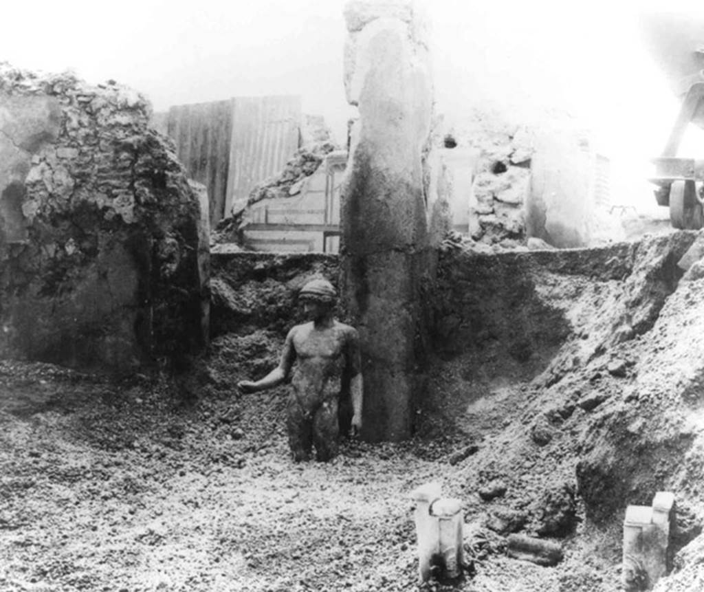 I.7.11 Pompeii. Found 25-26th May 1925, on south side of atrium near tablinum. Bronze statue of the ephebo. To the left can be seen the decoration of the south wall of the cubiculum. Photo courtesy of Davide Balzano. See Maiuri, A., 1928. Nuovi Scavi nella Via dell’Abbondanza. Milano: Hoepli. (p. 63).