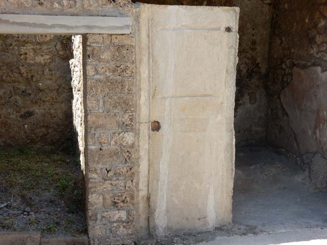 I.7.19 Pompeii. May 2017. Doorways to rooms in north-east corner of atrium, with plaster-cast of a door. Photo courtesy of Buzz Ferebee.
